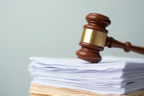 © johndaly - stock.adobe.com Foto: Richterhammer liegt auf Stapel Dokumente